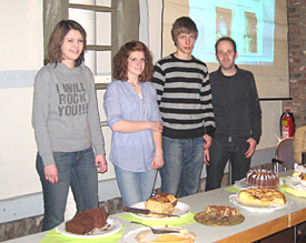 JJasmin, Sonja, Sebastian (v.l.) bieten mit EMG-Lehrkraft Thomas Knechten beim Tanz- und Kulturcaf&egrave; ihr Backwerk an 