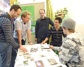 Sebastian Heinen, Serawer Shir und Thomas Knechten (v.r.) erl&auml;utern zwei Messebesuchern das EMG-Umweltkonzept 