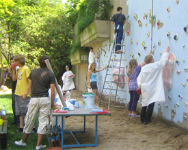 Sch&uuml;lerinnen und Sch&uuml;ler aus den Stufen 8 und 13 streichen die Kletterwand des neuen Schulgartens 