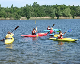 Wassersport bei besten Bedingungen: Einige Siebtkl&auml;ssler &uuml;ben sich auf dem Otto-Maigler-See im Kanufahren 