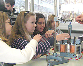 Bremsen ohne Reibung: Vier M&auml;dchen staunen &uuml;ber die Wirkung eines Magnetfeldes auf eine rotierende Metallscheibe 